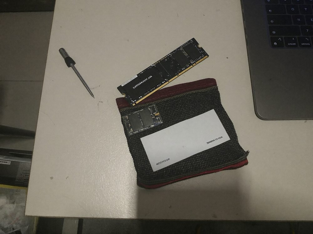 SSD M.2 și memorie RAM pregătite pentru montaj lângă un laptop deschis